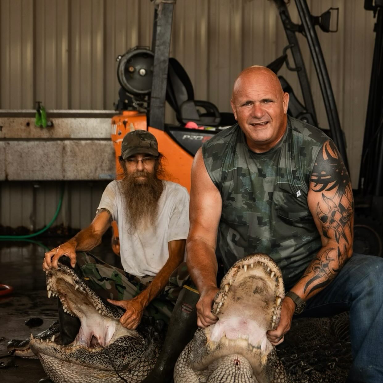 Ronnie Adams holding large alligators in a garage setting